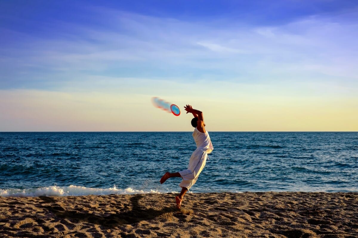 Persona Che Gioca A Frisbee Sulla Spiaggia