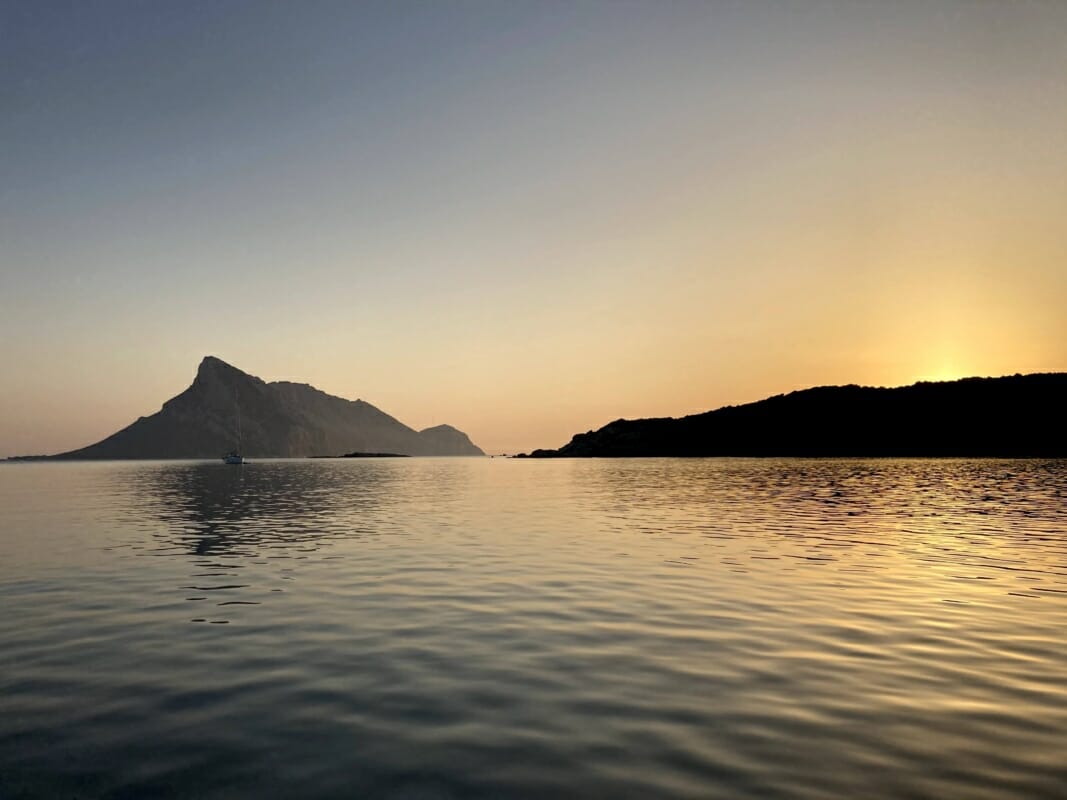 Cala Girgolu mit Blick auf die Insel Tavolara bei Sonnenuntergang